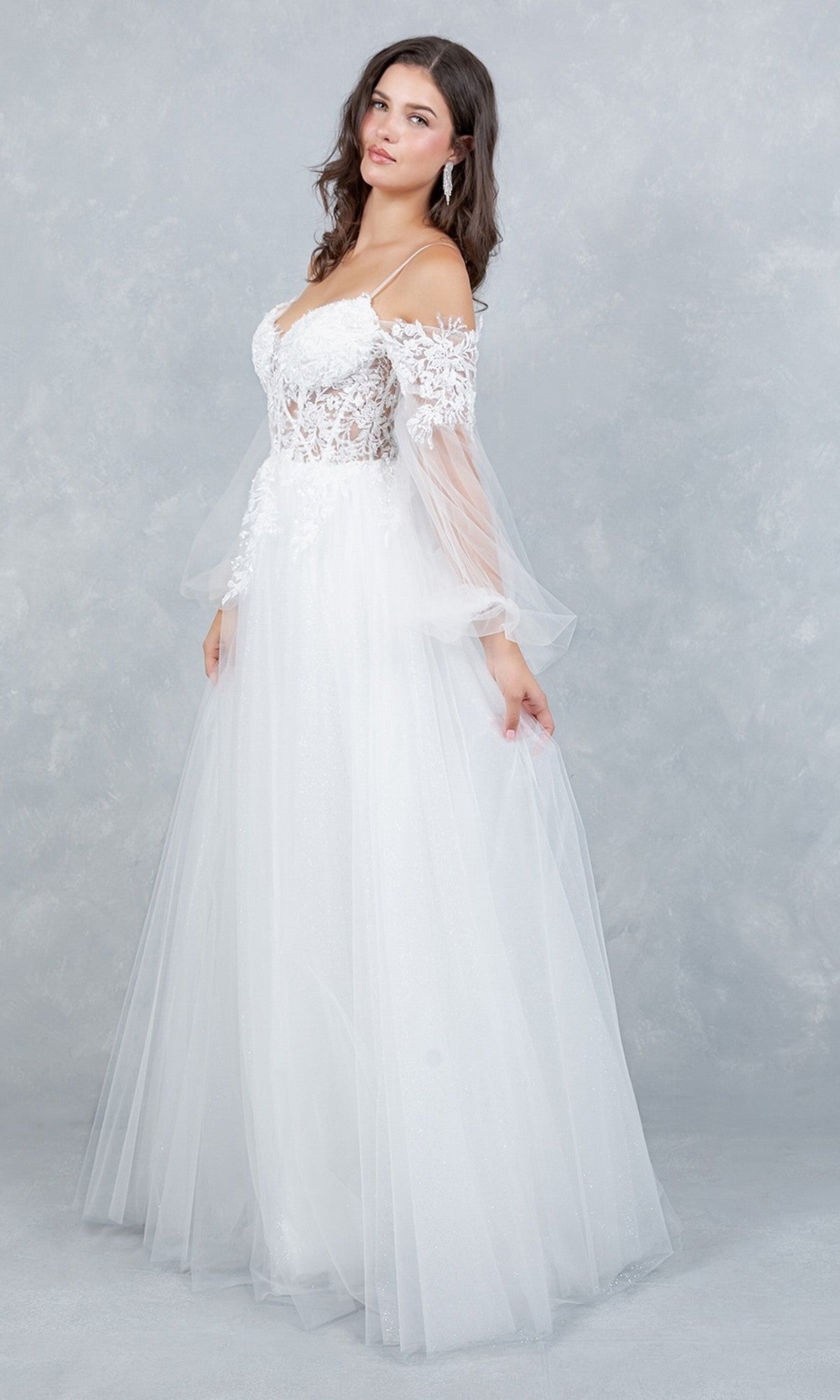 A woman stands against a light grey textured background wearing the Long Formal Dress: Cinderella Couture 4234 in Off White, featuring a delicate lace applique and an off-the-shoulder corset bodice.
